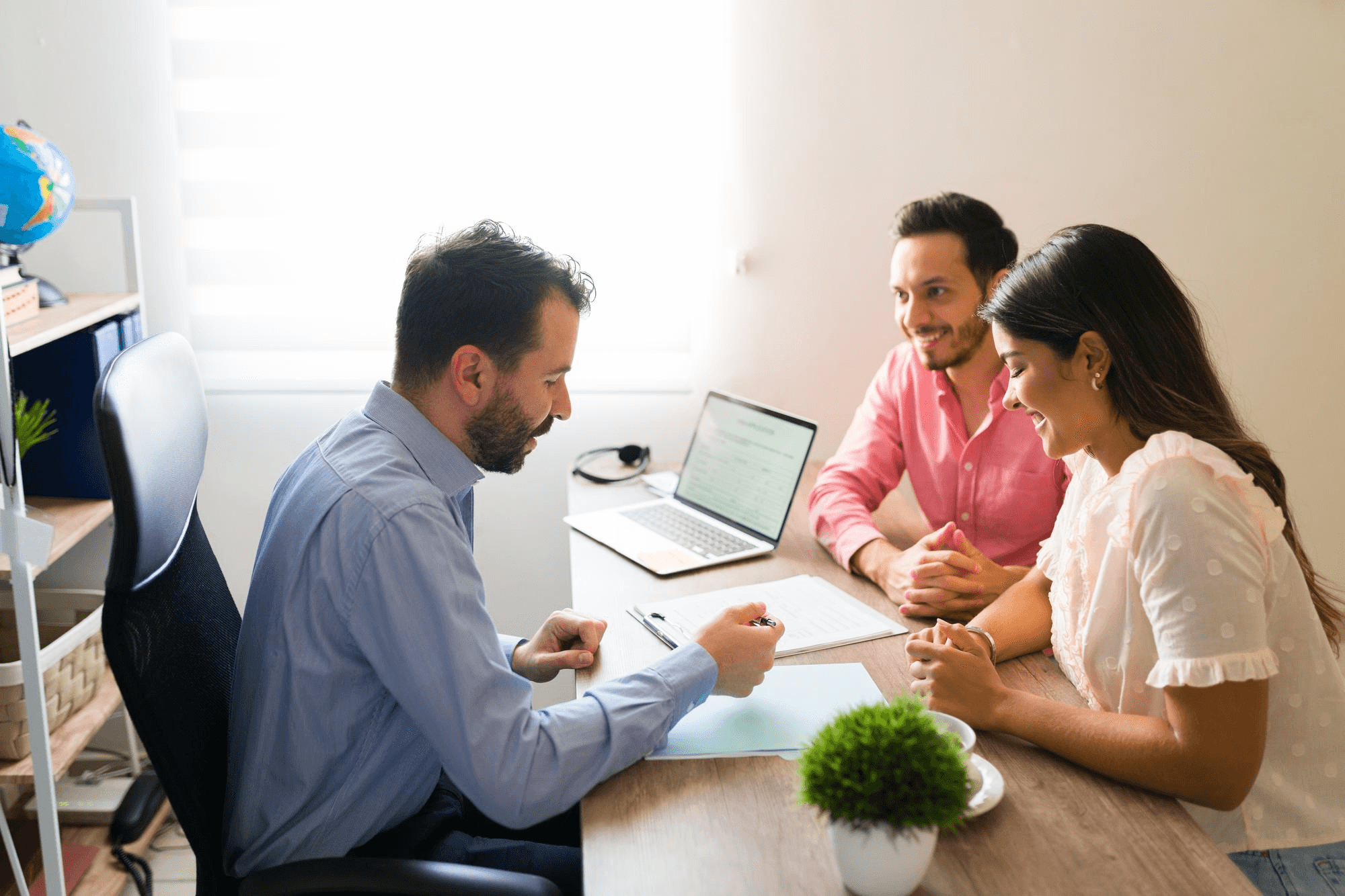 Young couple discussing life insurance plans with advisor.