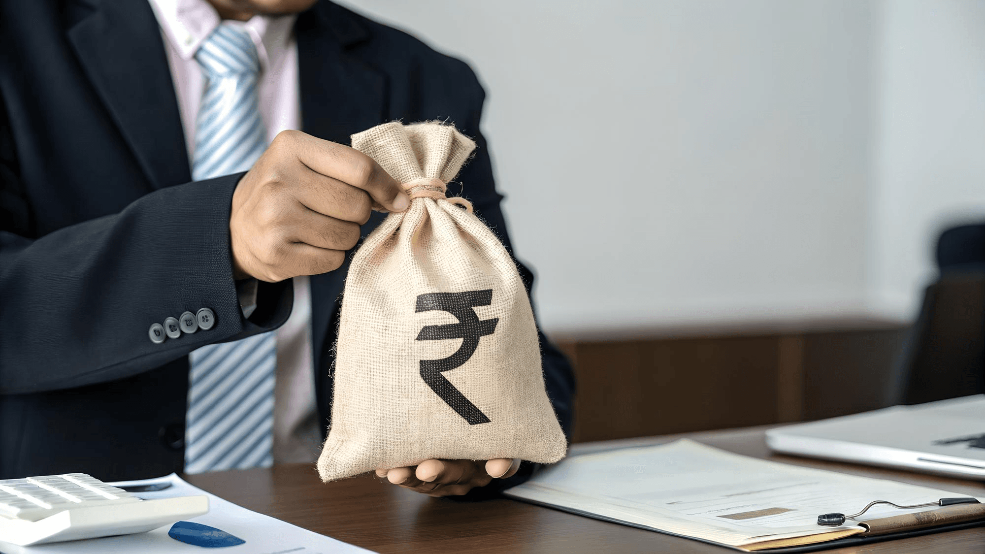 Man giving money sack with rupee sign.